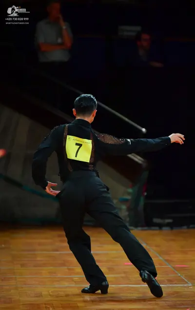 Dancesport competitor: Male dancer: black long-sleeved shirt with textured or sequin detail on the uppe