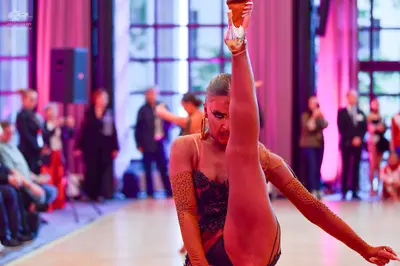 Dancesport competitor: Main female dancer: nude/tan latin dress with black lace/sequin patterns on the 