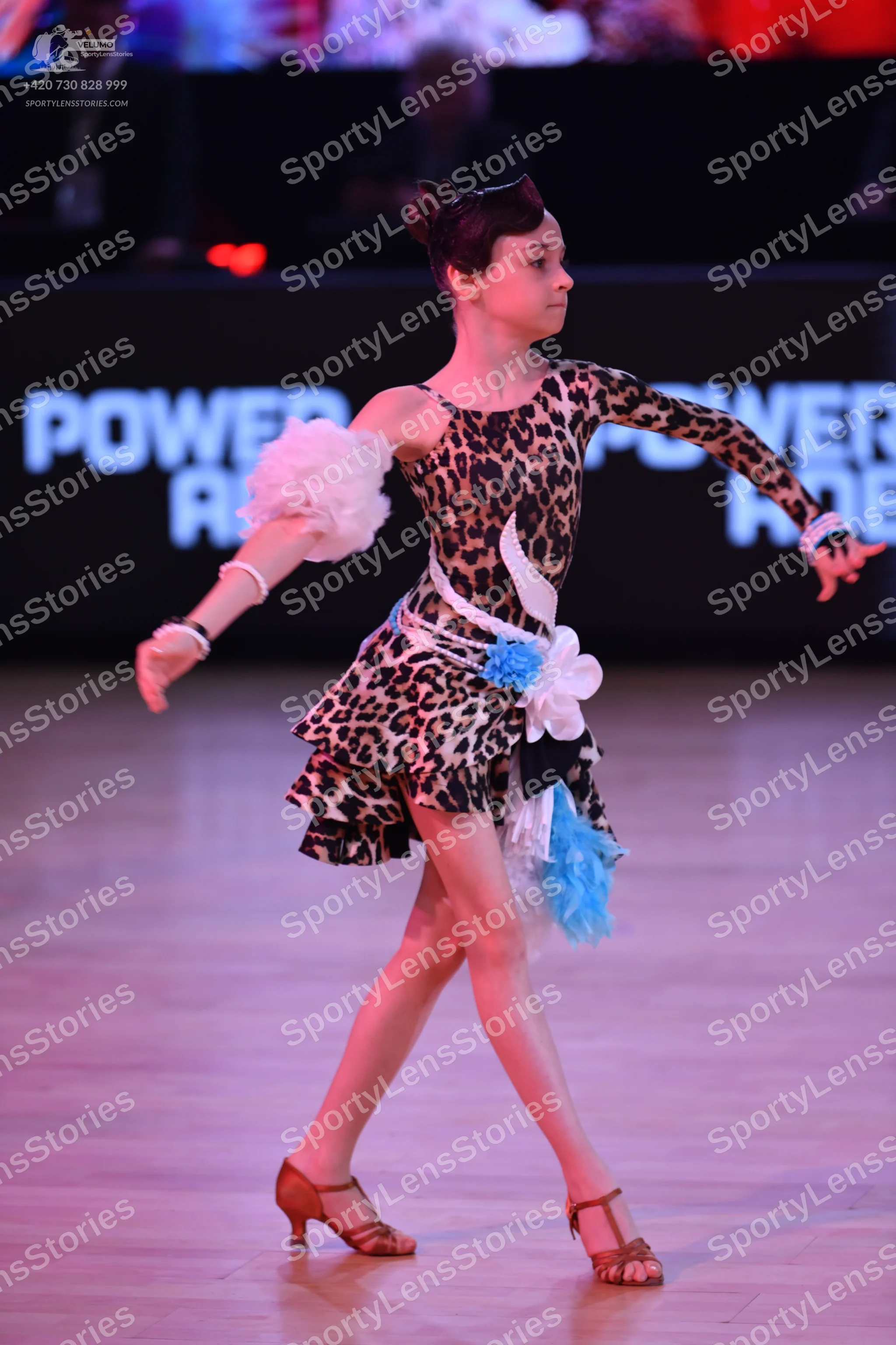 Dancesport competitor: Female dancer: leopard print latin dress with white and light blue fabric accent