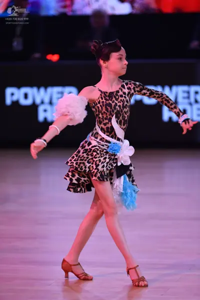 Dancesport competitor: Female dancer: leopard print latin dress with white and light blue fabric accent