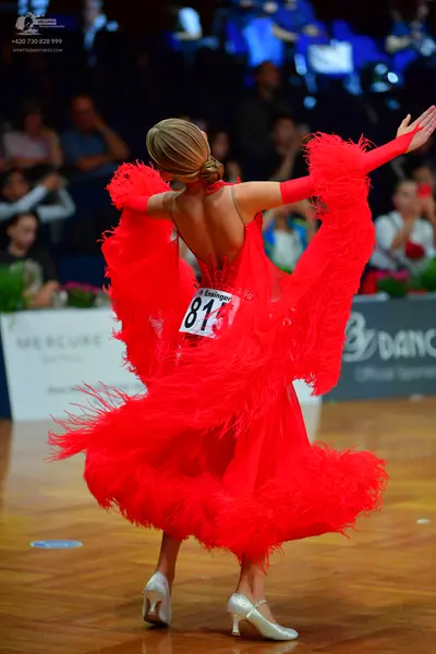 Dancesport competitor #81: Female dancer: red latin dress with long sleeves and heavy red fringe, and silve