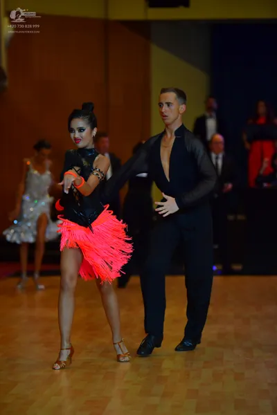 Dancesport competitor: ** Red Latin dress
*   **Fabric:** Primarily satin, with extensive fringe detail