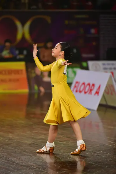 Dancesport competitor: Female dancer: yellow long-sleeved dress with a flared skirt