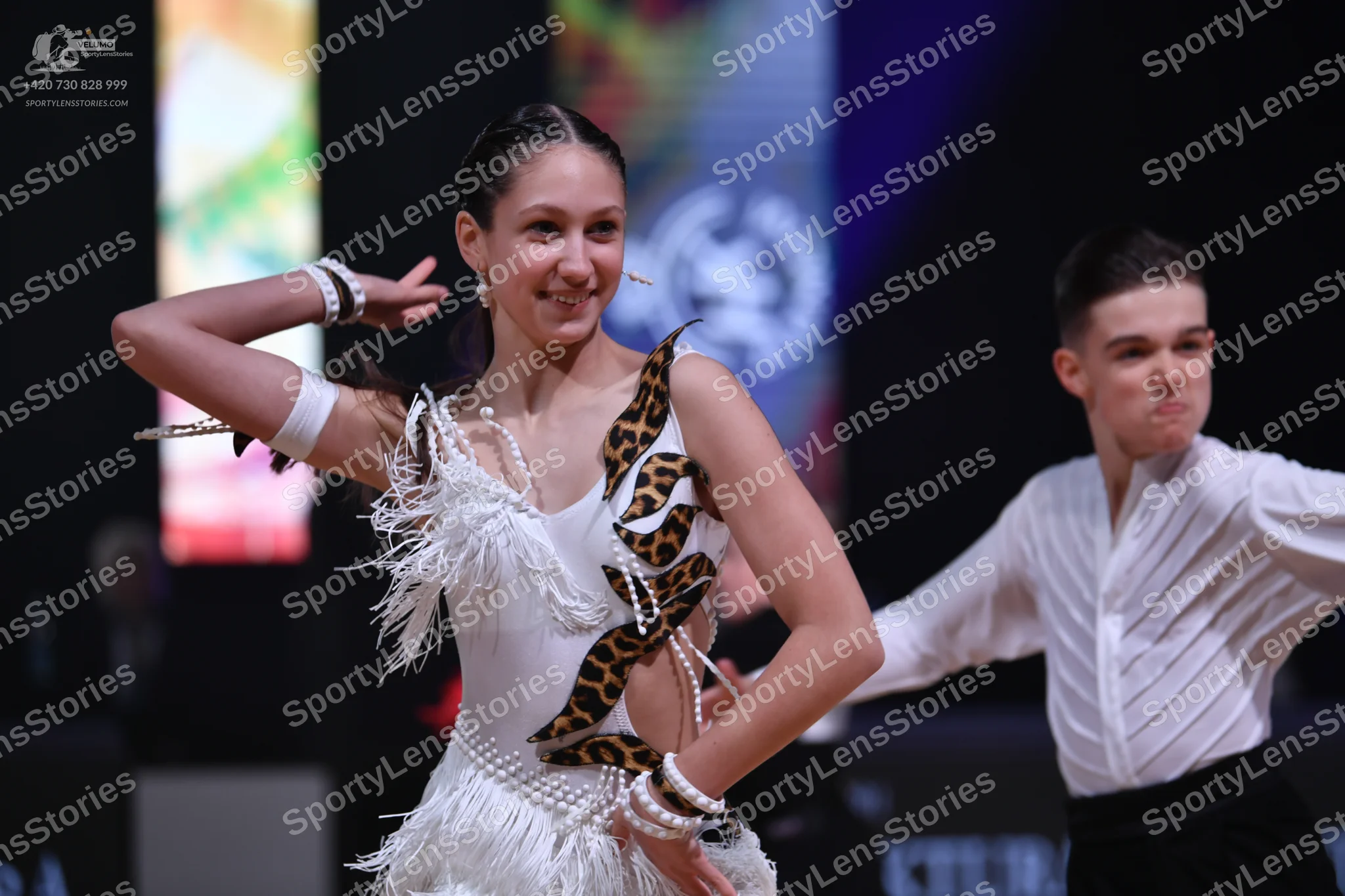 Dancesport competitor: Female dancer: white latin dress with leopard print pattern and white fringe, ac