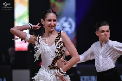 Dancesport competitor: Female dancer: white latin dress with leopard print pattern and white fringe, ac