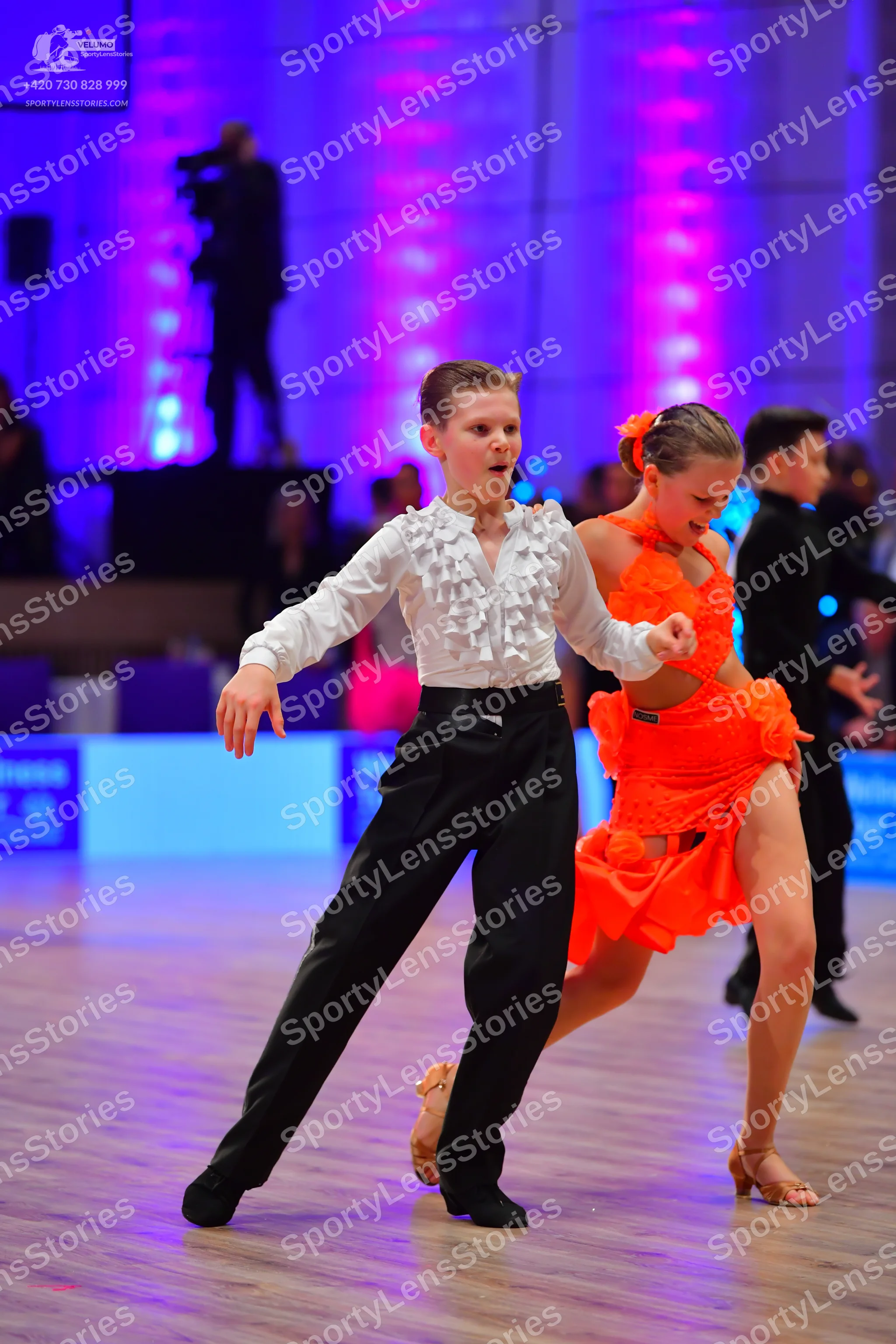 Dancesport competitor: Male dancer: white long-sleeved shirt with ruffles and black trousers