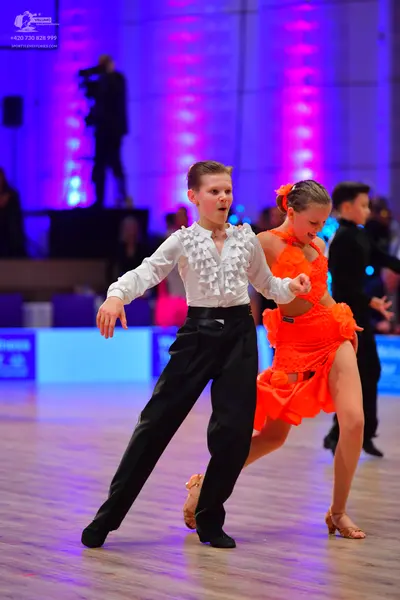 Dancesport competitor: Male dancer: white long-sleeved shirt with ruffles and black trousers