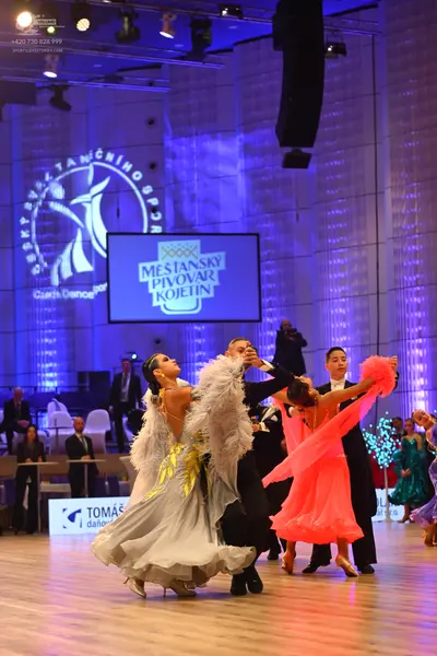 Dancesport competitor: Female dancer 1: white and silver ballgown with gold sequin embellishments on th