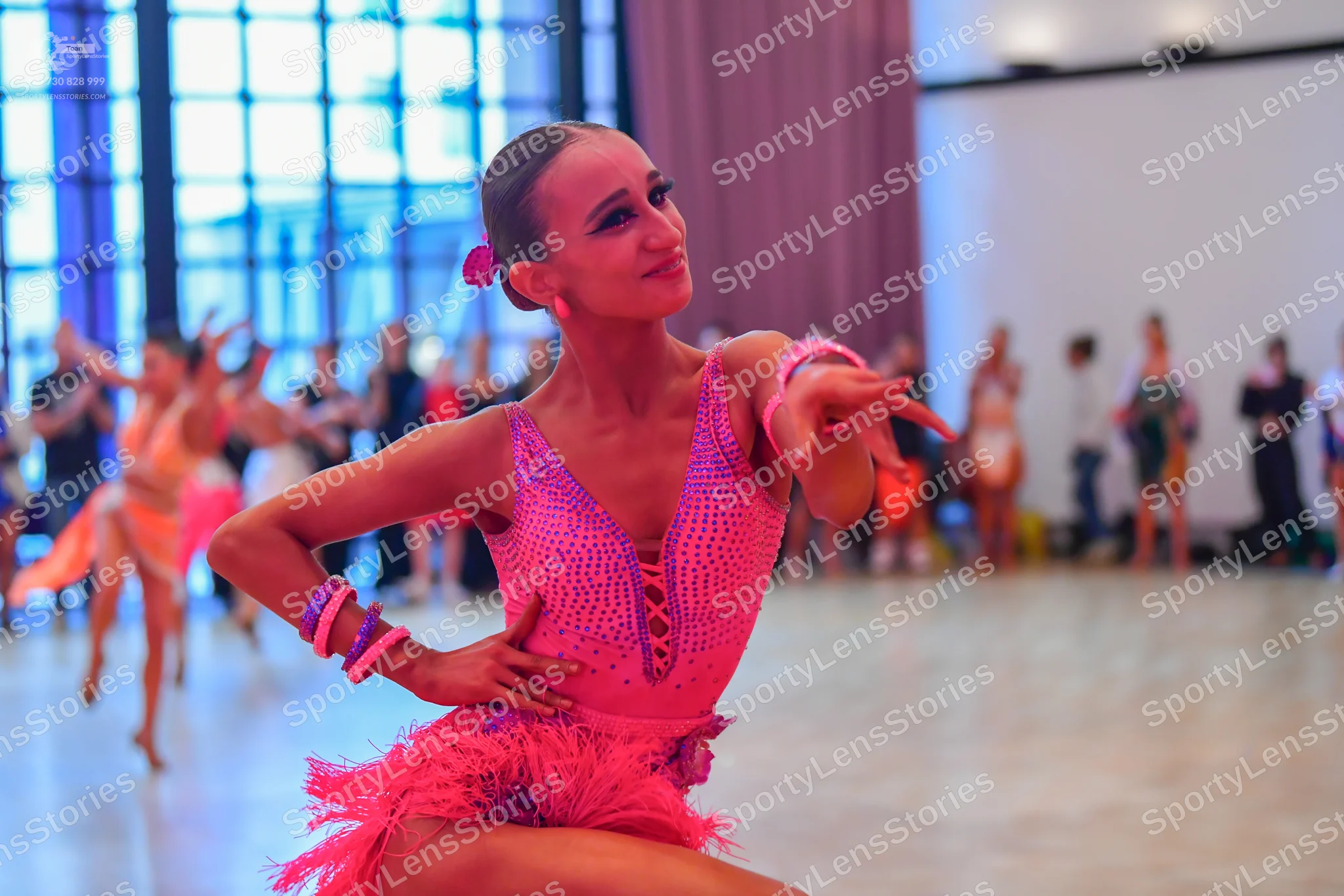 Dancesport competitor: Main female dancer: pink/magenta Latin dress with a sequined bodice and a fringe