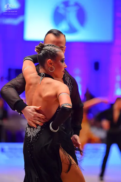 Dancesport competitor: Female dancer: black latin dress with silver rhinestone embellishments, fringe, 