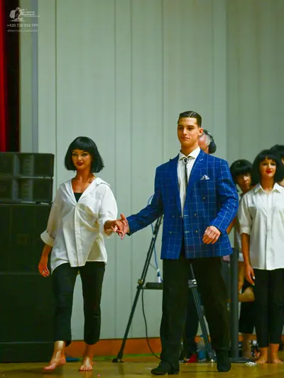 Dancesport competitor: Female dancer (left): white long-sleeved button-down shirt and black cropped tro