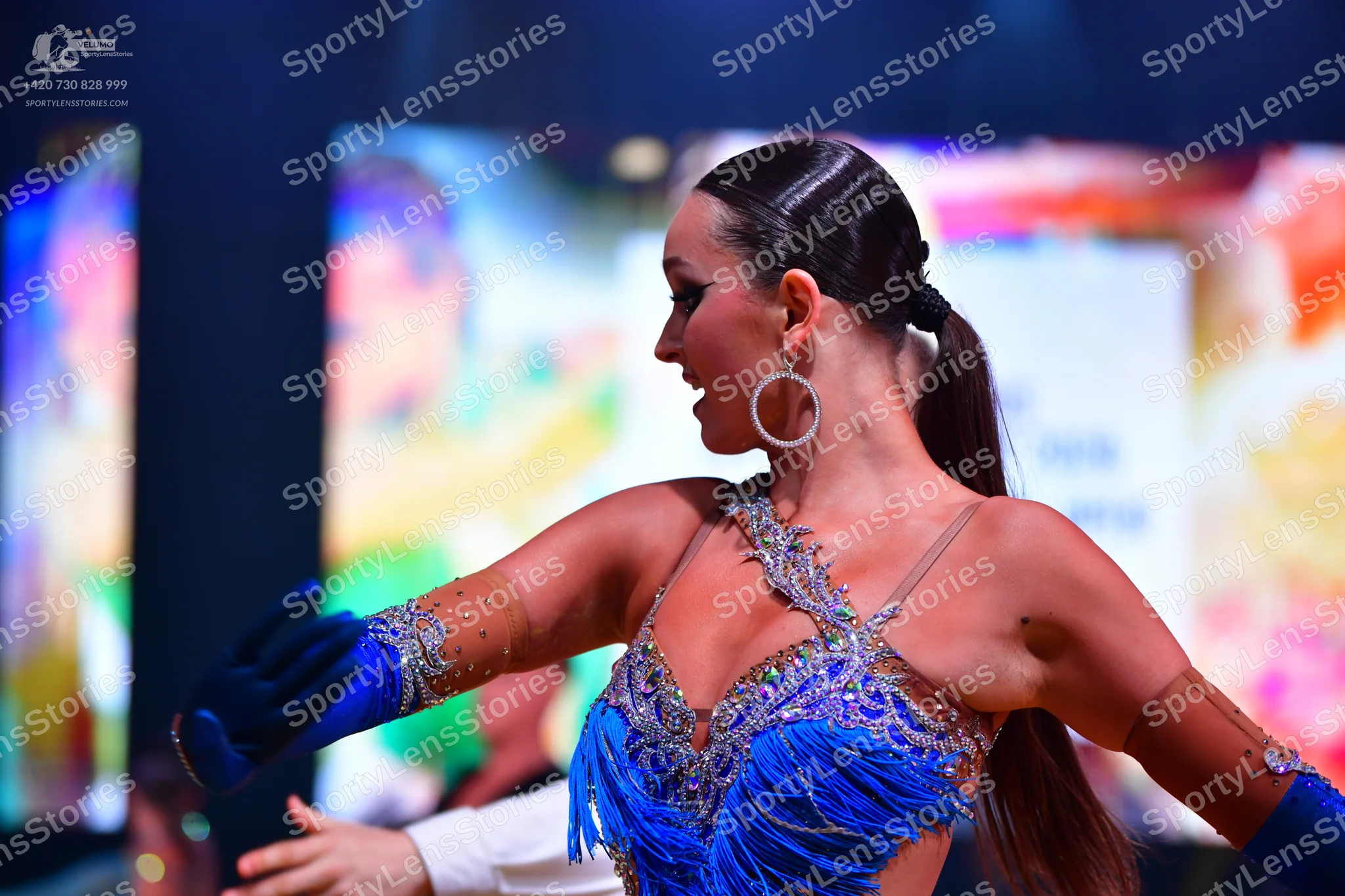 Dancesport competitor: Female dancer: Blue Latin dress with crystal/sequin embellishments, blue fringe,
