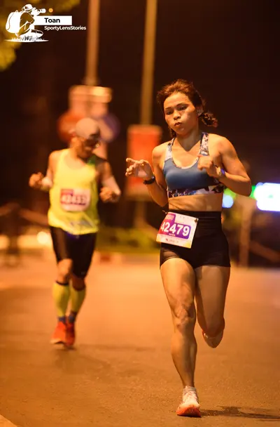 Marathon runner #42479: Runner 1: blue patterned sports bra, black shorts, white shoes