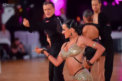 Dancesport competitor: Male dancer (foreground): black long-sleeved shirt and black trousers
