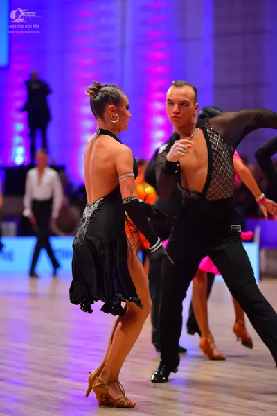 Dancesport competitor: Female dancer: black Latin dance dress with sequin embellishments, sleeveless, w