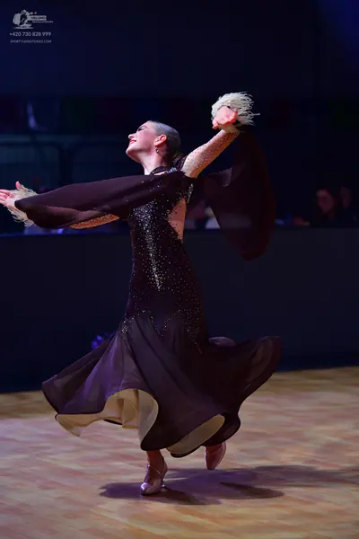 Dancesport competitor: Female dancer: dark brown/burgundy ballroom dress with a sequined bodice and lar