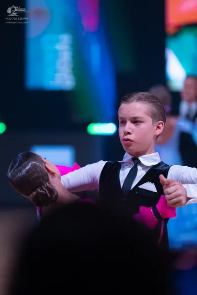 Dancesport competitor: Male dancer: white long-sleeved shirt, black vest, black necktie, and a white po