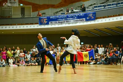 Dancesport competitor: Male dancer: blue suit jacket with shiny lapels, white shirt, and black trousers