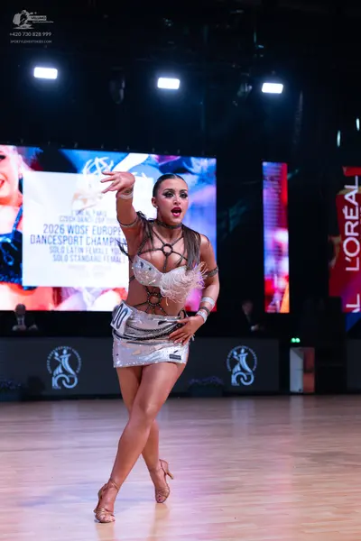Dancesport competitor: Female dancer: silver sequined latin costume with a bra-style top and a short sk