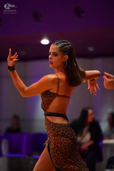 Dancesport competitor: Female dancer: leopard print latin dress with sequins, featuring a high slit and