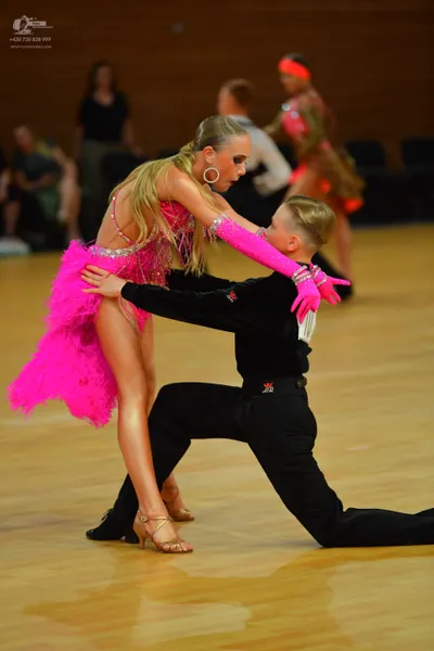 Dancesport competitor: Here's a breakdown of the dancers' costumes in the photo, formatted as requested