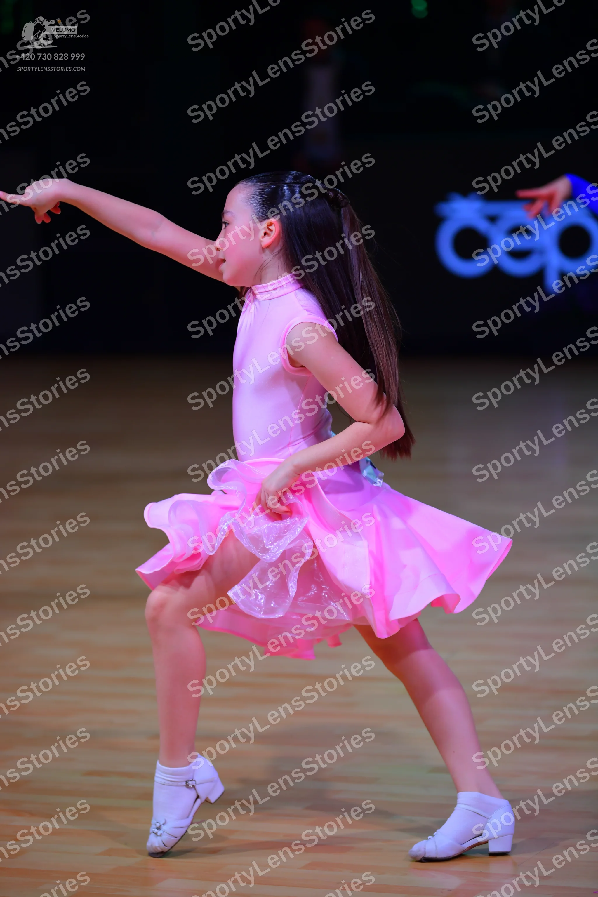 Dancesport competitor: Female dancer: pink sleeveless Latin dance dress with a high neck and a volumino