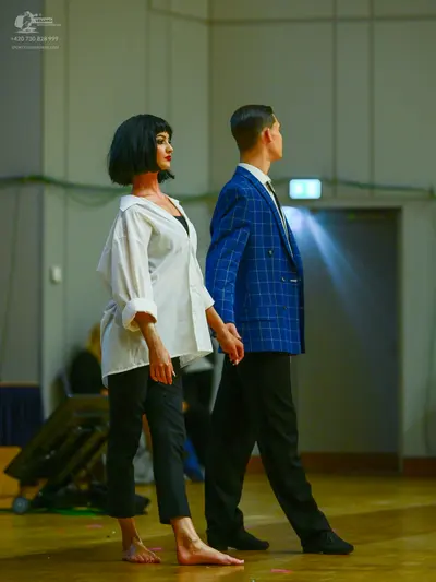 Dancesport competitor: Female dancer: white long-sleeved button-down shirt with rolled-up sleeves and b