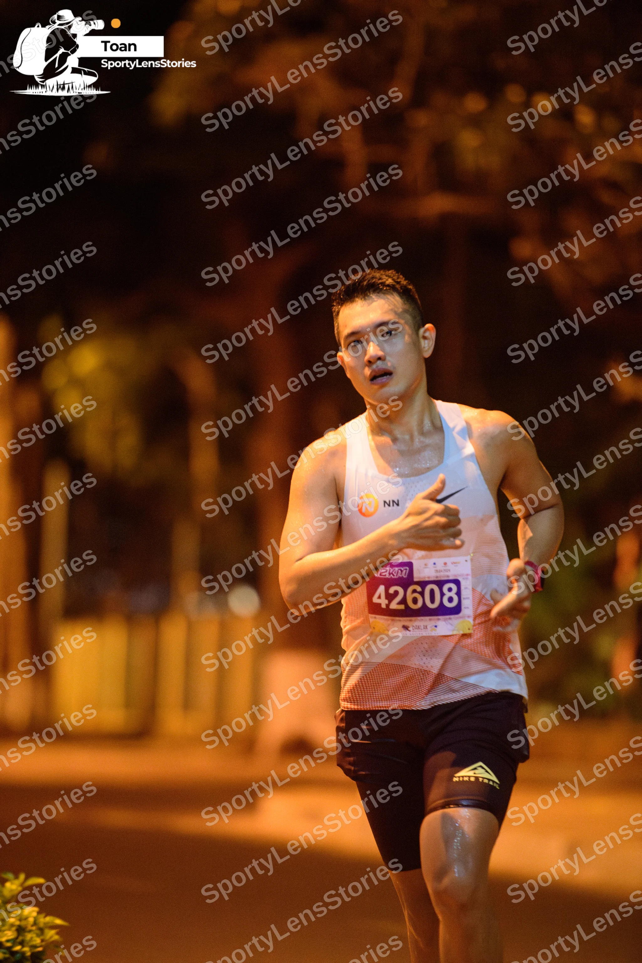Marathon runner #42608: Runner 1: white tank top, black shorts, watch on left wrist