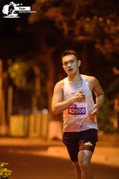Marathon runner #42608: Runner 1: white tank top, black shorts, watch on left wrist