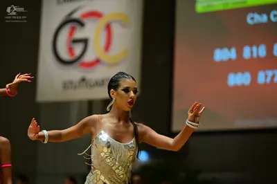 Dancesport competitor: Primary female dancer: silver sequin Latin dress with thin straps and metallic f