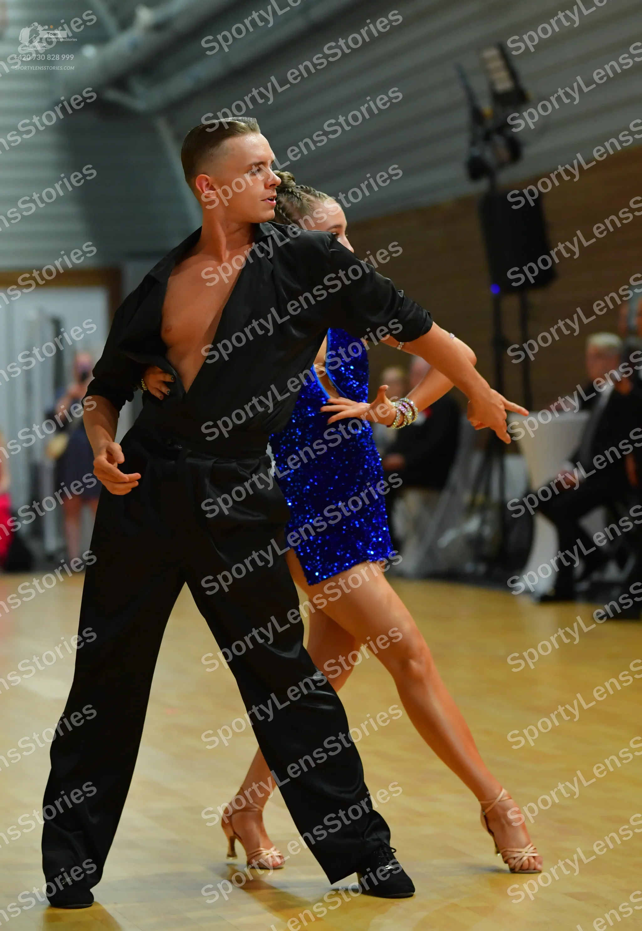 Dancesport competitor: ** Black tail suit with a wide, shimmering sequin lapel detail