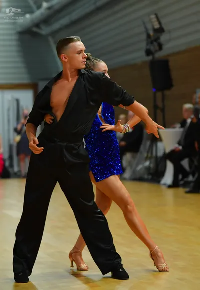 Dancesport competitor: ** Black tail suit with a wide, shimmering sequin lapel detail