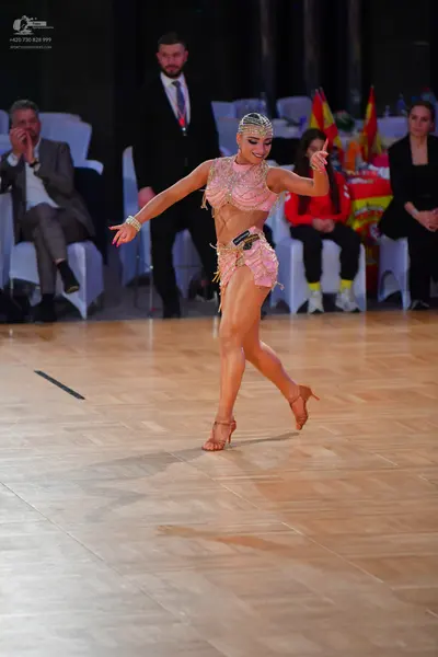 Dancesport competitor: Female dancer: champagne-colored Latin dance costume embellished with rhinestone
