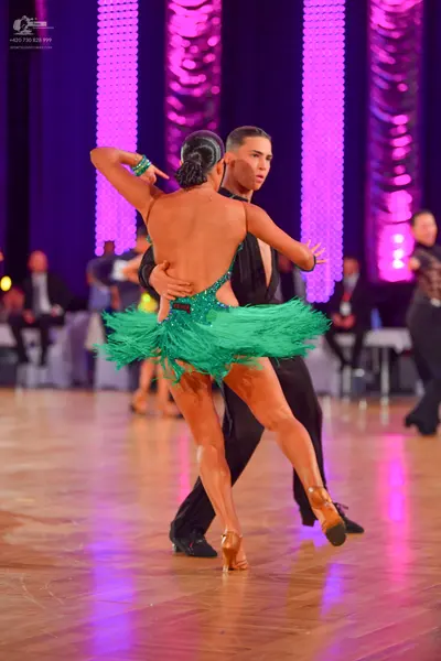 Dancesport competitor: Female dancer: green latin dress with heavy fringe and black sequined detailing,