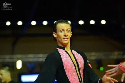 Dancesport competitor: Male dancer: Black and pink Latin dance shirt with a pink sequined panel on the 