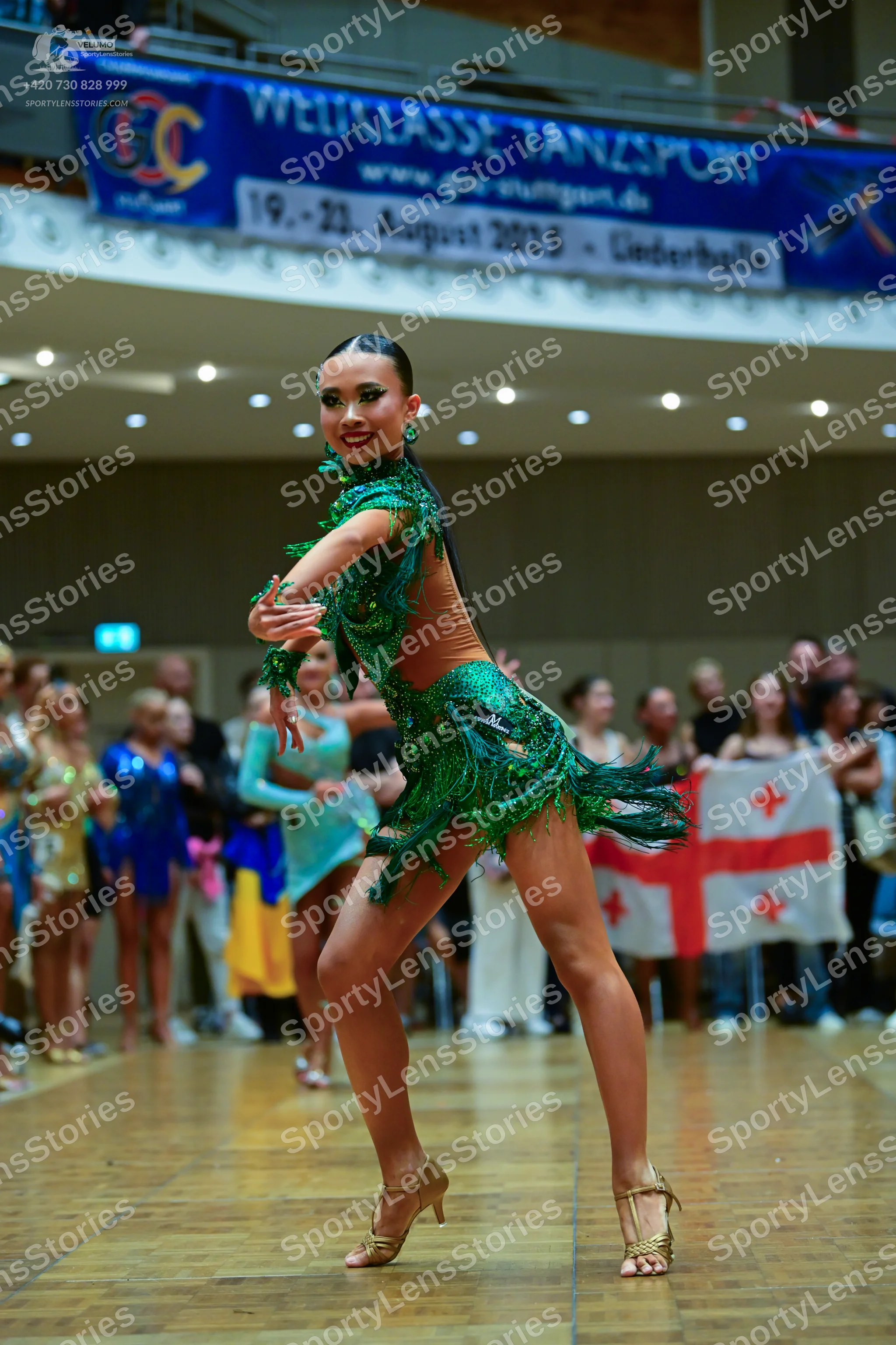 Dancesport competitor: Main female dancer: green latin dress with fringe, sequins, and embellishments