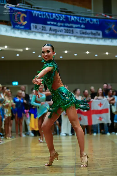 Dancesport competitor: Main female dancer: green latin dress with fringe, sequins, and embellishments