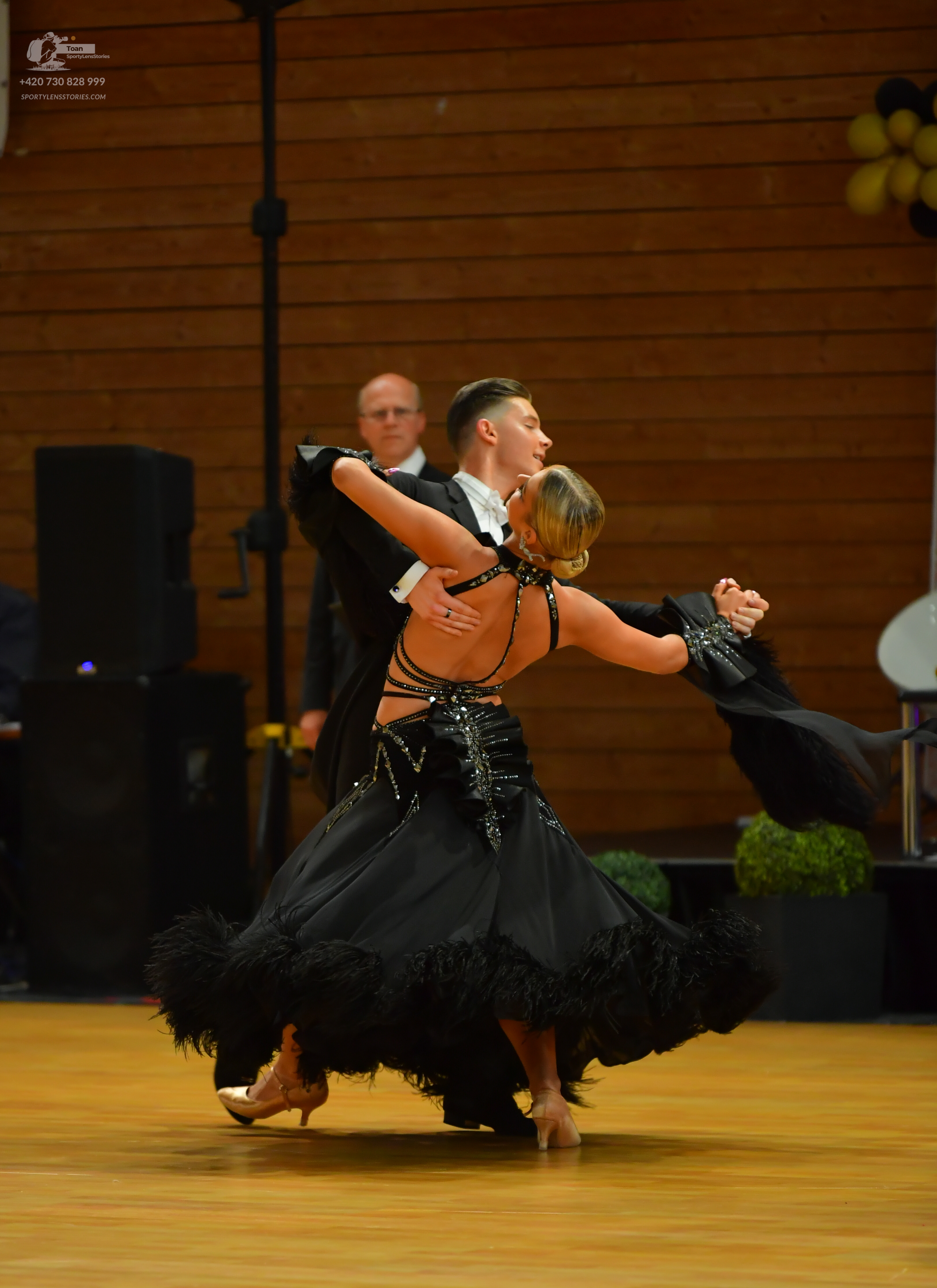 Dancesport competitor: Male:** Black tailsuit with iridescent sequin lapels and a wide, flowing black t