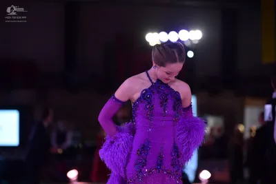 Dancesport competitor: Female dancer: purple Latin dance dress with sequins, crystals, and feather-like