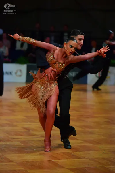 Dancesport competitor: Female dancer: gold latin dress with sequins and fringe, including a matching se