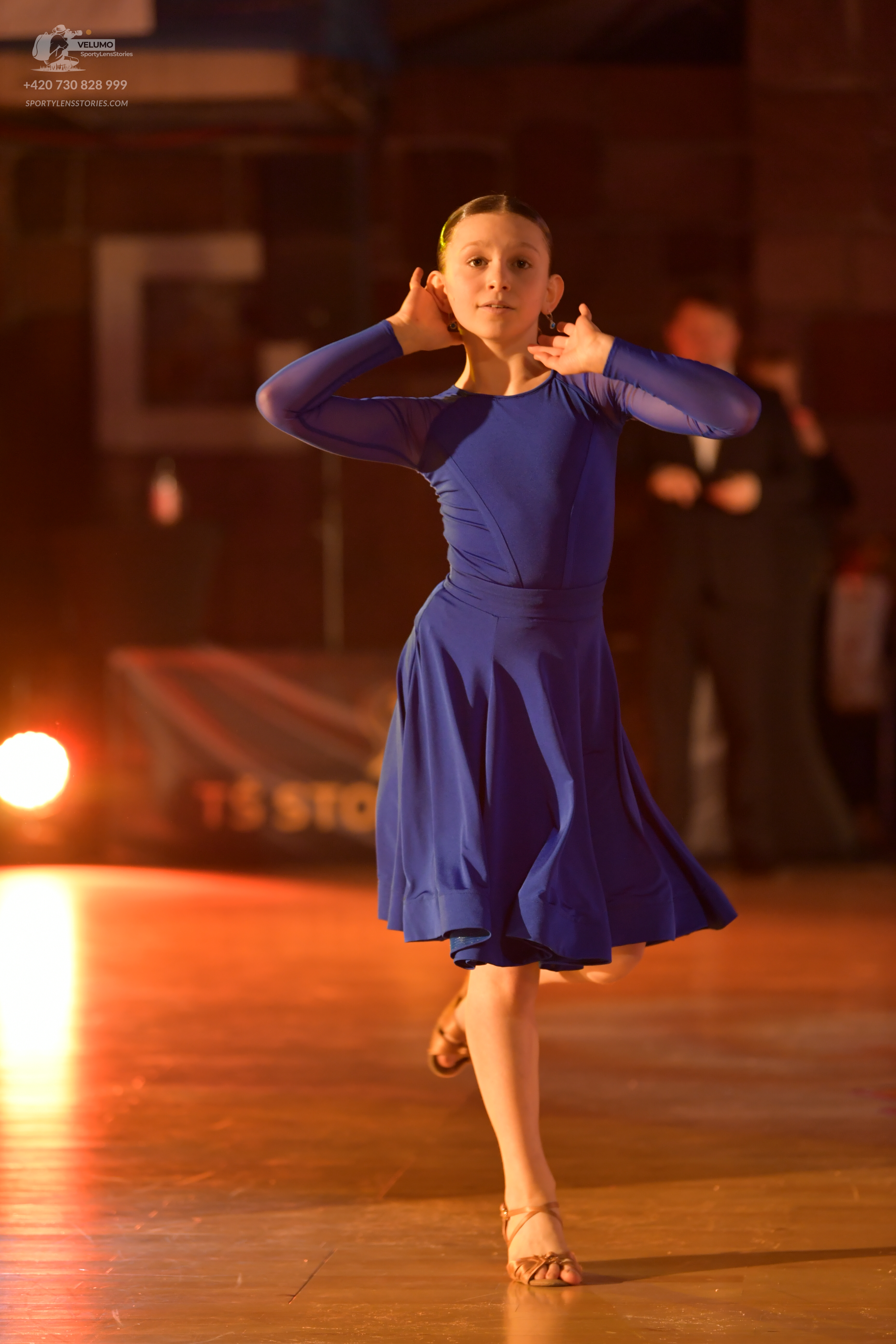 Dancesport competitor: Female dancer: blue long-sleeved knee-length dress with smooth fabric