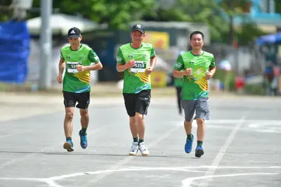 Marathon runner #5358: Runner 1: green and yellow jersey, black shorts, black cap, blue shoes