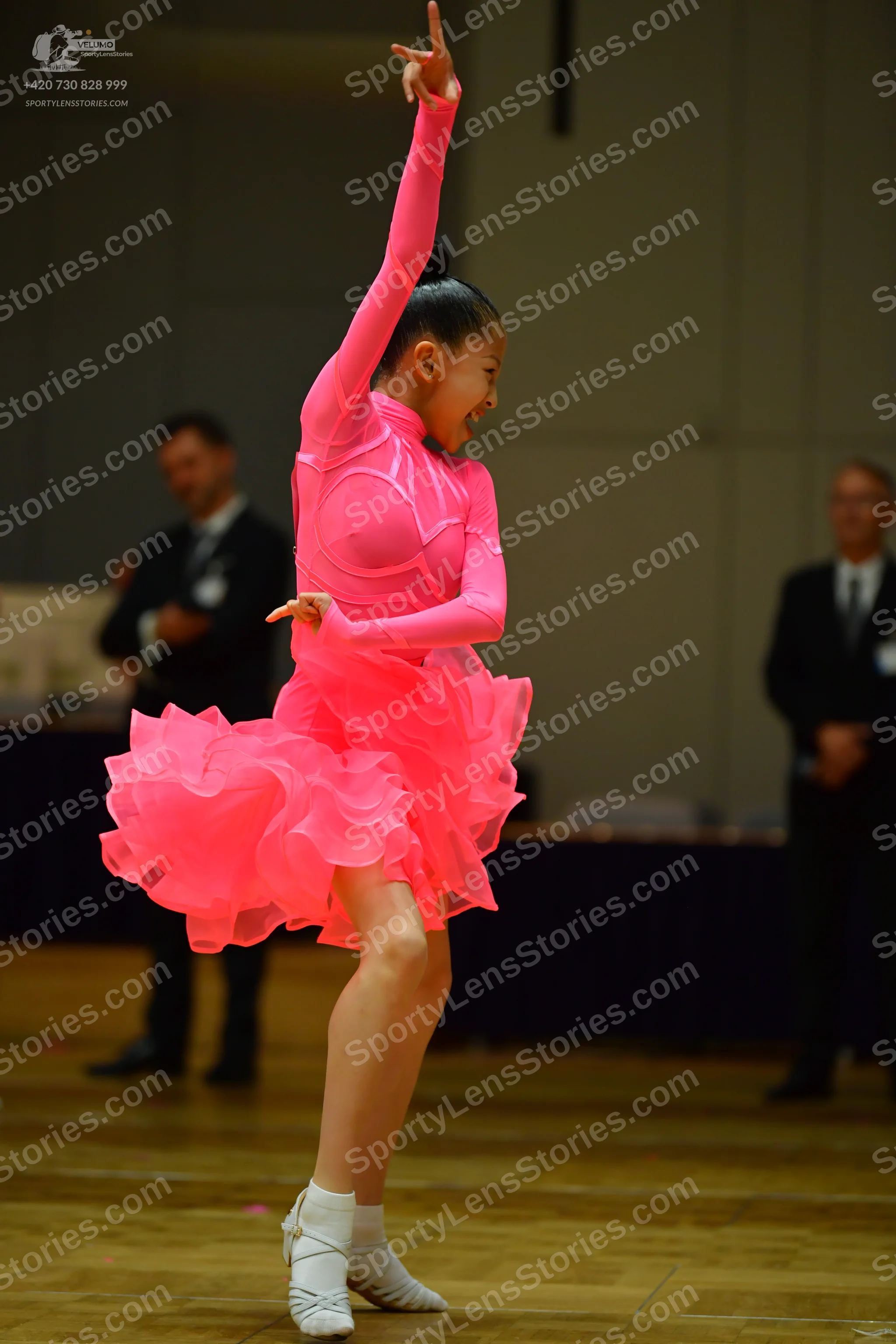 Dancesport competitor: Female dancer: bright pink long-sleeved Latin dress with a voluminous ruffled sk