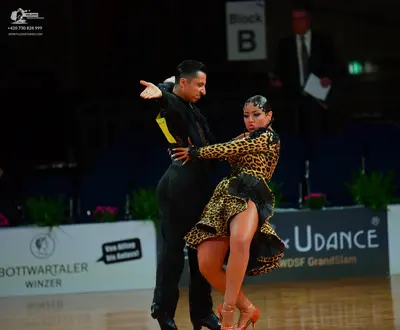 Dancesport competitor: Male dancer: black long-sleeved Latin dance shirt with yellow accents and black 