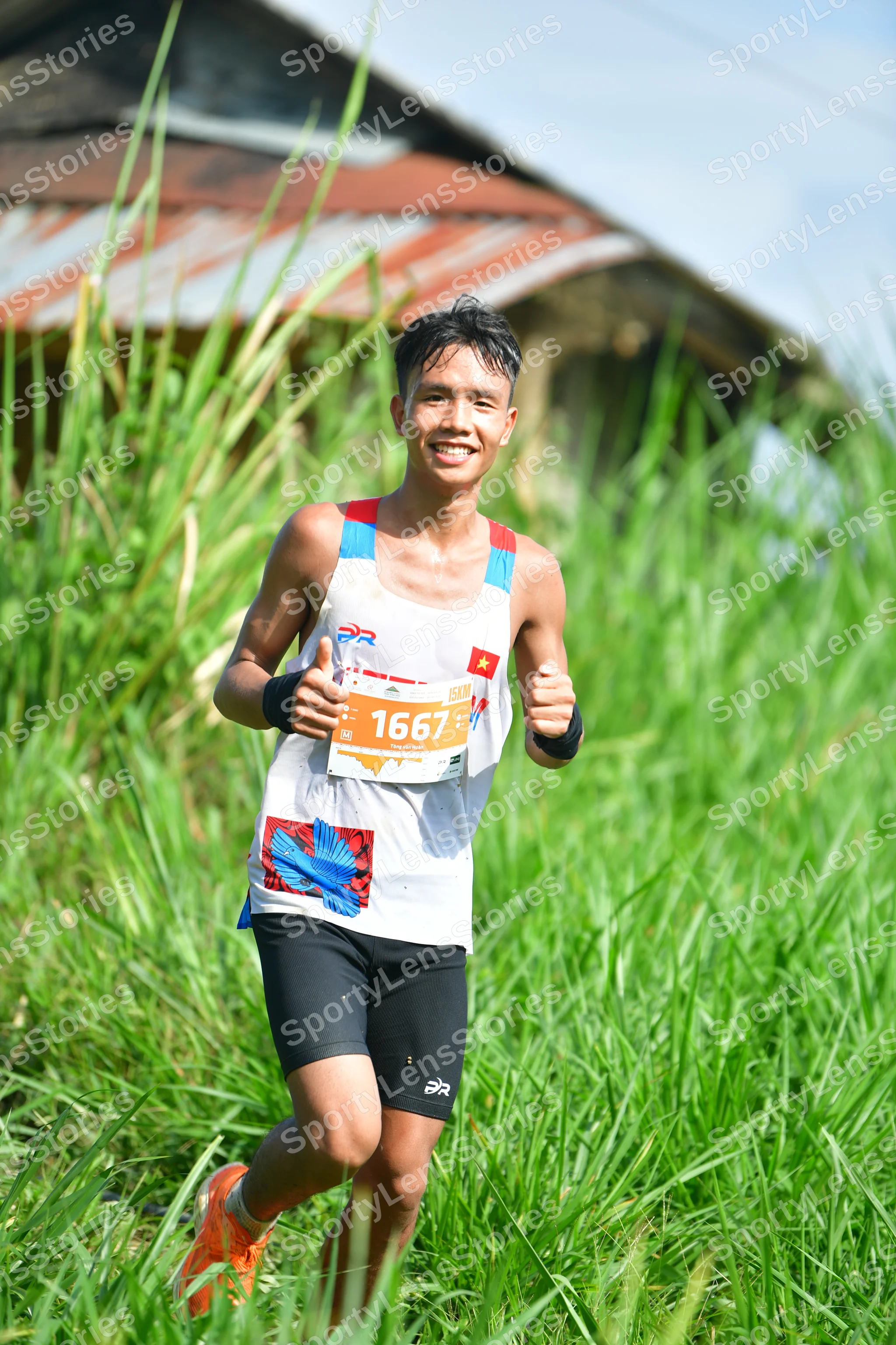 Marathon runner #1667: Runner 1: white tank top with graphics, black shorts, orange shoes, black wristb