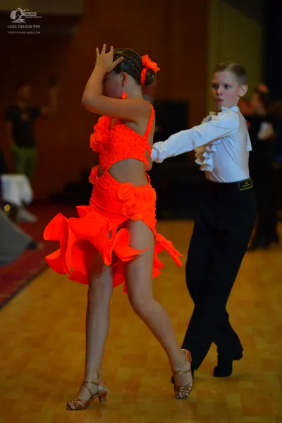 Dancesport competitor: Male dancer: white long-sleeved shirt with ruffles and black trousers
