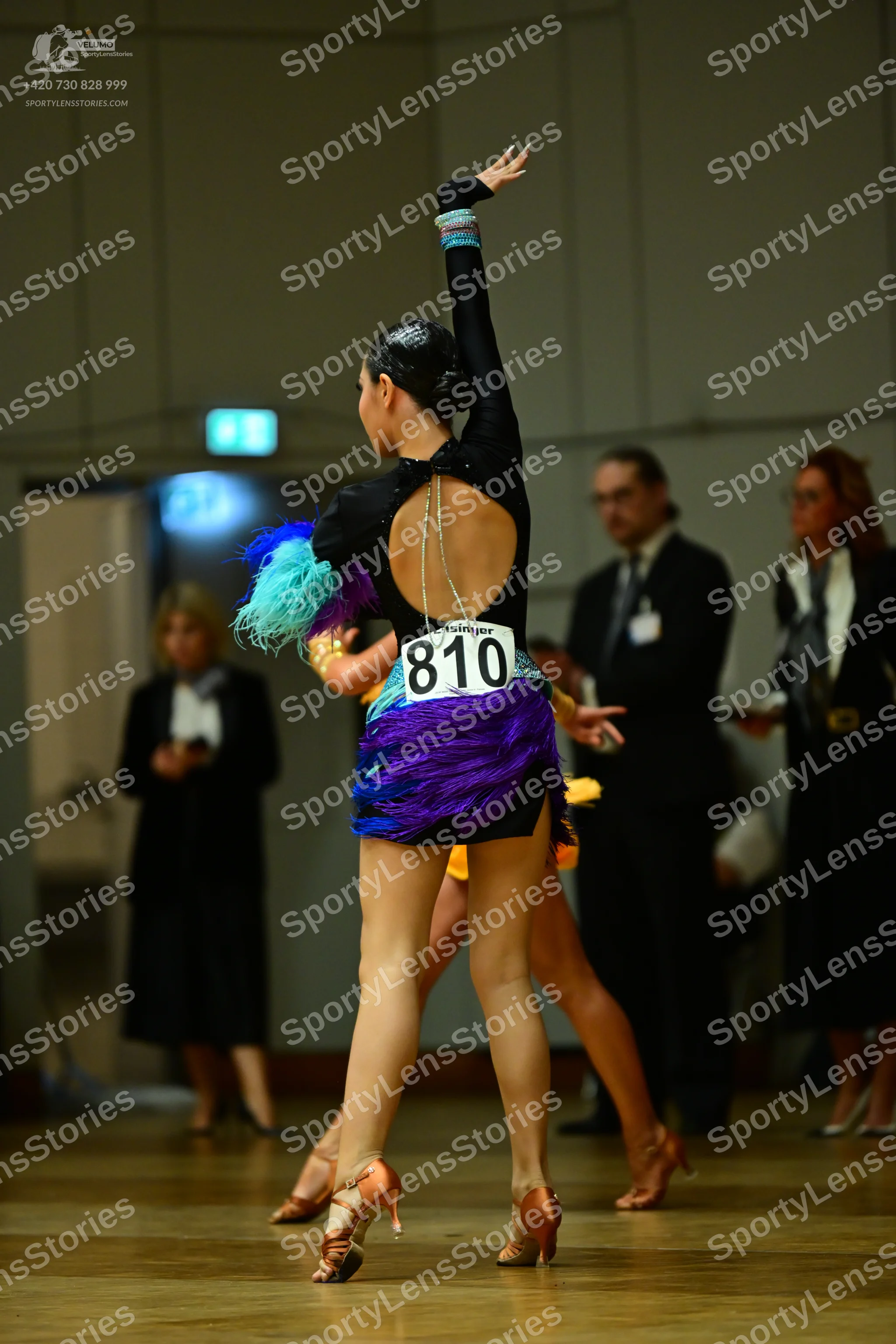 Dancesport competitor #810: Female dancer: black long-sleeved Latin dress with an open back and a silver cha