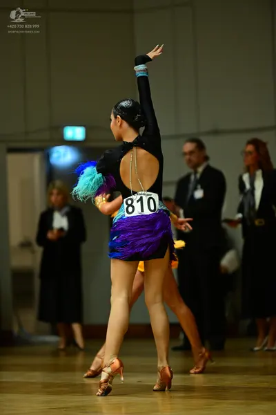 Dancesport competitor #810: Female dancer: black long-sleeved Latin dress with an open back and a silver cha