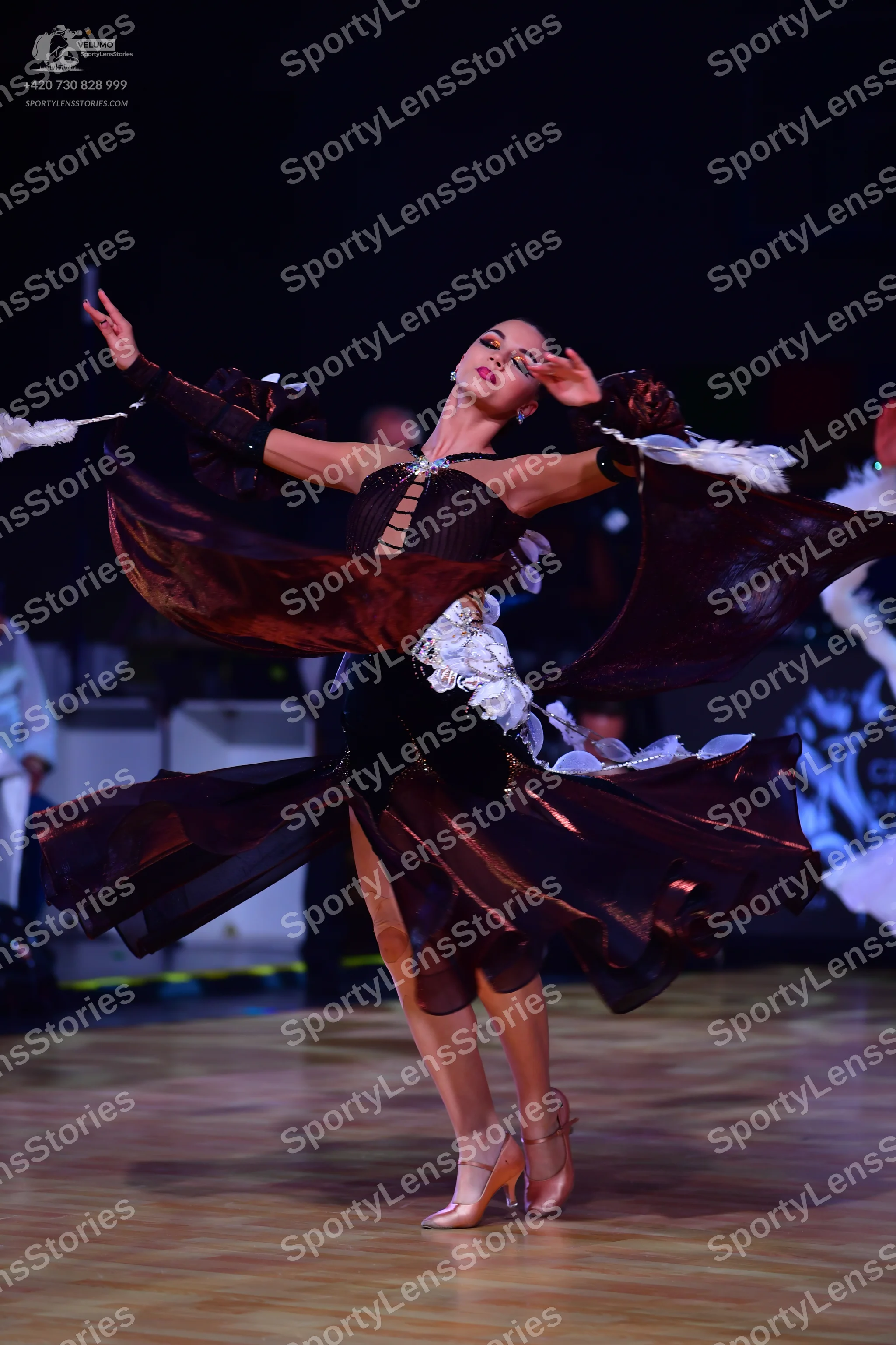Dancesport competitor: Female dancer: dark burgundy flowing Latin dance dress with large, dramatic, ruf