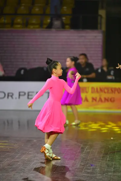 Dancesport competitor: Female dancer: bright pink long-sleeved dress